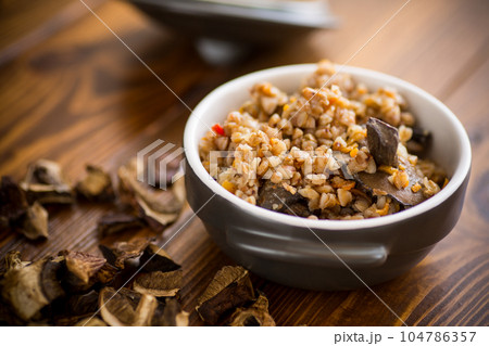 boiled buckwheat with organic forest dried mushrooms in a ceramic bowl 104786357