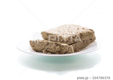 piece of sweet halva on white background piece of sweet halva on white background 104786378