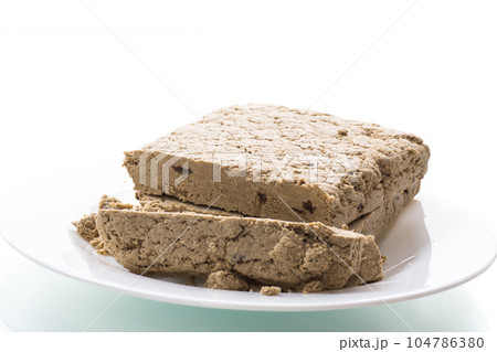 piece of sweet halva on white background 104786380