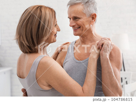 Happy senior couple dancing together at home Happy senior couple dancing together at home 104786815