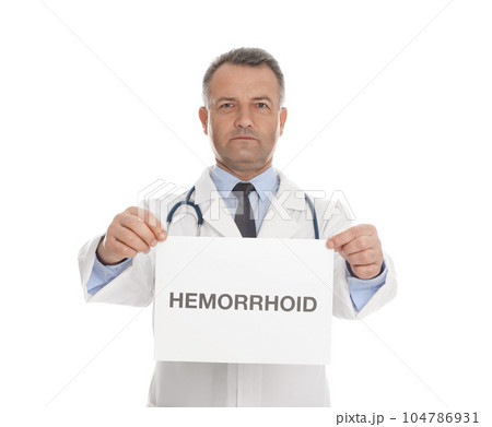 Doctor holding sign with word HEMORRHOID on white background Doctor holding sign with word HEMORRHOID on white background 104786931