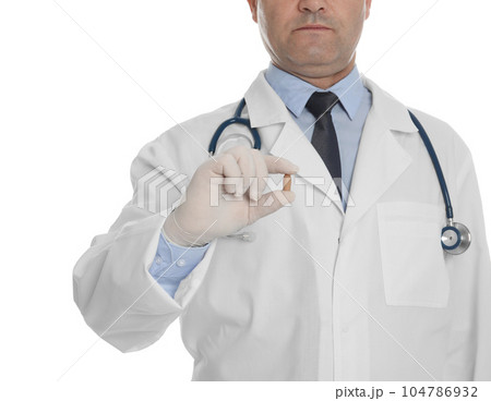 Doctor holding suppository for hemorrhoid treatment on white background, closeup 104786932