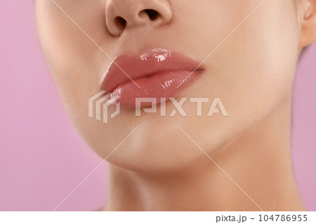 Young woman with beautiful full lips on pink background, closeup 104786955