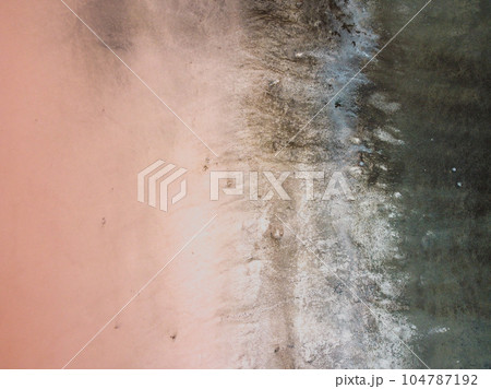A bird's eye view of a red salt lake and black earth, captured by a drone. A bird's eye view of a red salt lake and black earth, captured by a drone. 104787192
