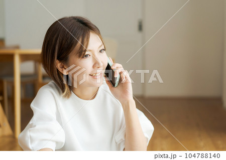 リビングで電話をする女性の写真 リビングで電話をする女性の写真 104788140