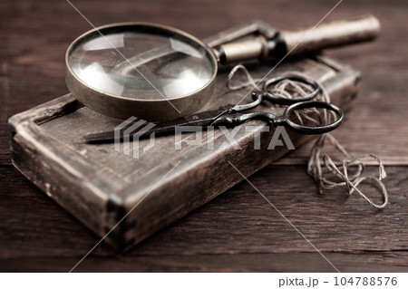 Antique accessories wooden box, old vintage retro scissors and magnifying glass. Antique accessories wooden box, old vintage retro scissors and magnifying glass. 104788576