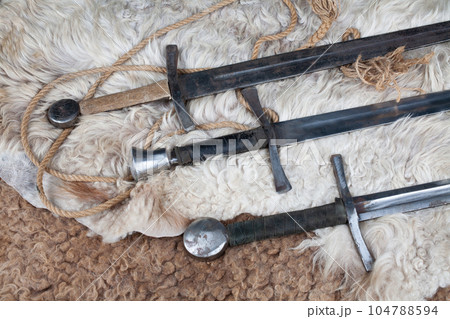 Medieval swords on sheep fur 104788594