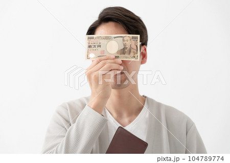 1万円札で顔を隠す男性 104789774