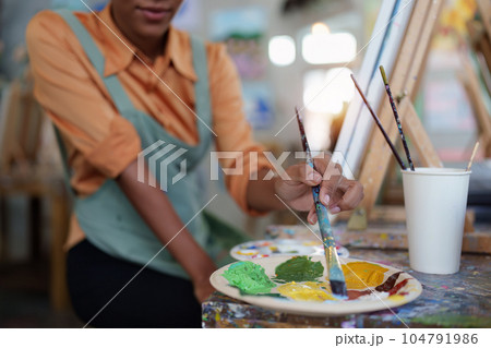 Beautiful american african artist woman painting in art studio at the university classroom 104791986