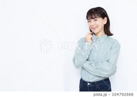 白い背景の前で笑顔で考えている30代の女性 104792666