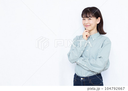 白い背景の前で笑顔で考えている30代の女性 104792667