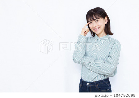 白い背景の前で笑顔で考えている30代の女性 104792699