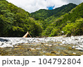 青空の下、川沿いキャンプでベージュのテント設営 104792804