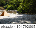 川沿いキャンプでベージュのテントと小さな滝 104792805