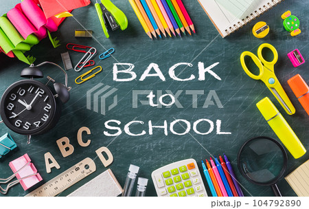 Education or back to school Concept. Top view of Colorful school supplies with books, color pencils, calculator, pen cutter clips chalkboard background. Education or back to school Concept. Top view of Colorful school supplies with books, color pencils, calculator, pen cutter clips chalkboard background. 104792890