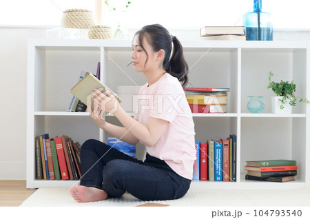 本棚の前で洋書を読む女性 104793540