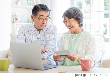 リビングでパソコンを見るシニア夫婦 104793769