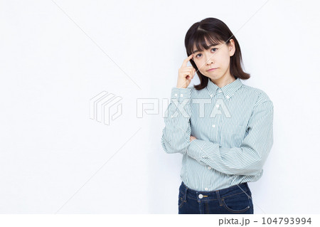 白い背景の前で真剣に悩んでいる30代の女性 白い背景の前で真剣に悩んでいる30代の女性 104793994