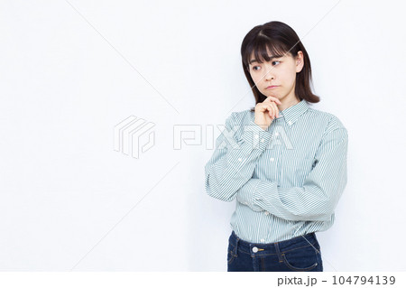 白い背景の前で真剣に悩んでいる30代の女性 白い背景の前で真剣に悩んでいる30代の女性 104794139