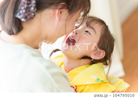 七五三の着物を着た女の子を抱きしめるお母さん 七五三の着物を着た女の子を抱きしめるお母さん 104795010