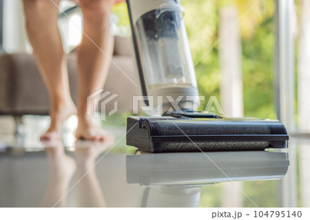 Modern vacuum cordless vacuum cleaner with water nozzle for cleaning floors. Close-up of a washing vacuum cleaner on the floor House cleaning 104795140