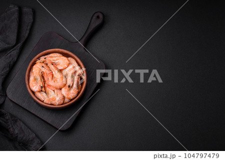 Delicious fresh boiled tiger prawns with salt and spices on a ceramic plate 104797479