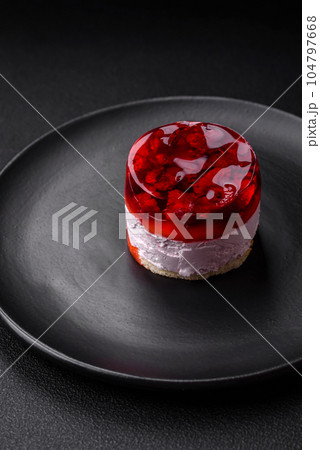 Delicious fresh sweet cheesecake cake with berries and red color jelly 104797668
