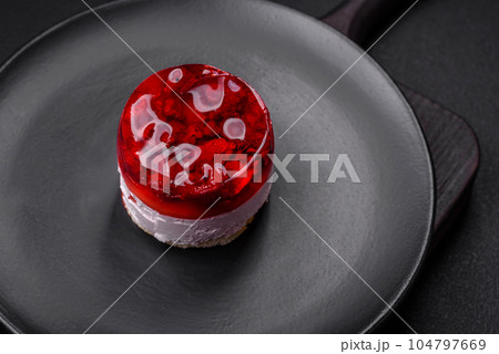 Delicious fresh sweet cheesecake cake with berries and red color jelly 104797669
