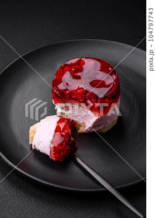 Delicious fresh sweet cheesecake cake with berries and red color jelly Delicious fresh sweet cheesecake cake with berries and red color jelly 104797743
