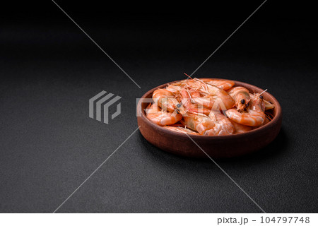 Delicious fresh boiled tiger prawns with salt and spices on a ceramic plate 104797748