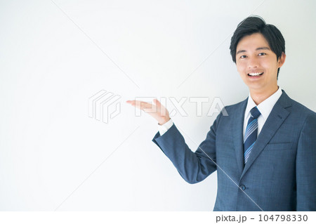 カメラ目線で紹介ポーズを取るビジネスマン 104798330