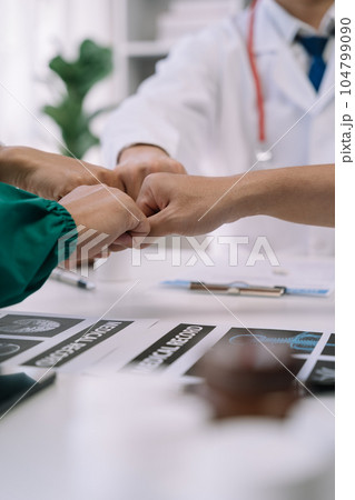 Doctors shaking hands, working together as a team at the hospital. 104799090