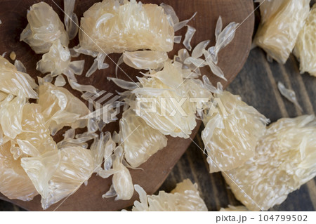 Freshly peeled pink pomelo on the table Freshly peeled pink pomelo on the table 104799502