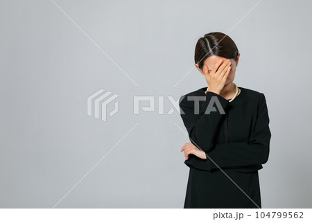 顔を覆う喪服の女性 104799562