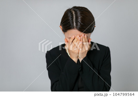 顔を覆う喪服の女性 104799564
