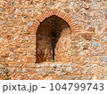 An ancient stone wall of Alanya fortress with an arched window 104799743