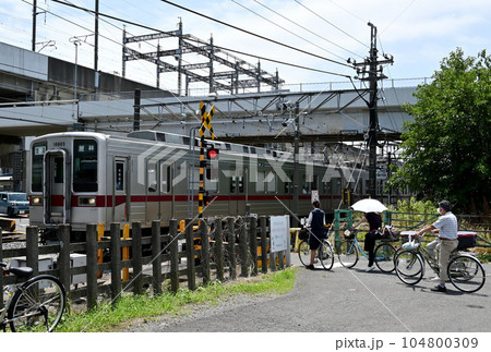 遮断機が降りて踏切を待つ風景 遮断機が降りて踏切を待つ風景 104800309