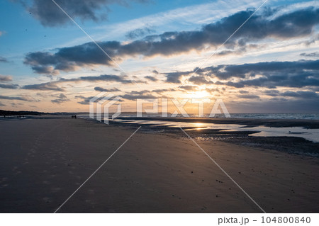 Dramatic Sunset Sky Reflected in the Beach and Sea Waves Dramatic Sunset Sky Reflected in the Beach and Sea Waves 104800840