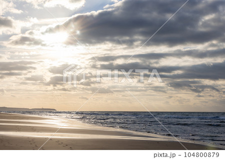Dramatic Sunset Sky Reflected in the Beach and Sea Waves 104800879