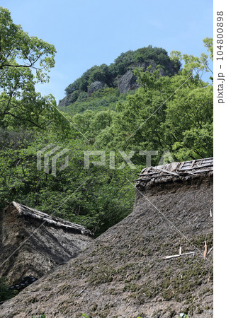 四国村ミウゼアム 石畳広場から見る屋島南嶺と河野家住宅（1700年代前半、国指定重要文化財） 104800898