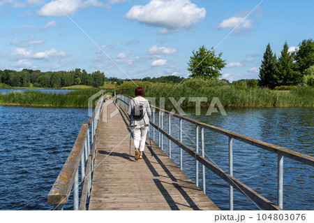Back view of unidentifiable woman with trekking sticks Back view of unidentifiable woman with trekking sticks 104803076