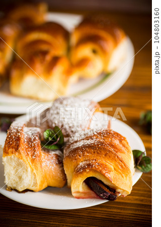 baked sweet homemade buns with plum inside baked sweet homemade buns with plum inside 104803160
