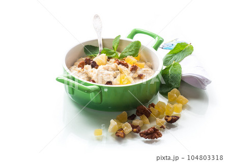 cooked boiled sweet oatmeal with nuts and candied fruits in a bowl 104803318