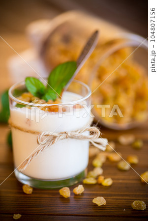 sweet homemade yogurt with raisins in a glass sweet homemade yogurt with raisins in a glass 104807156