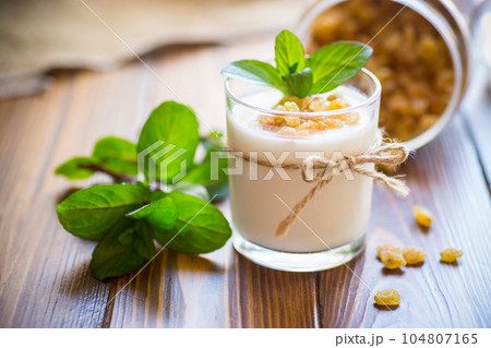 sweet homemade yogurt with raisins in a glass sweet homemade yogurt with raisins in a glass 104807165