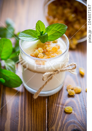 sweet homemade yogurt with raisins in a glass sweet homemade yogurt with raisins in a glass 104807167