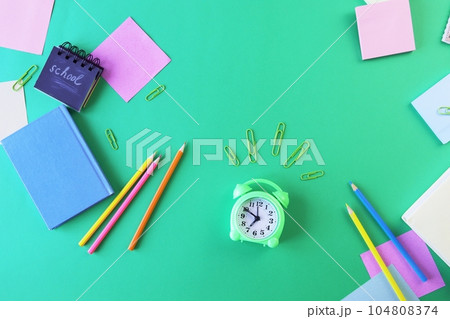 School supplies and an alarm clock on a green background. Back to school concept 104808374