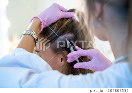 Woman head and doctor's hands with syringe, professional mesottherapy procedures, vitamin injections Woman head and doctor's hands with syringe, professional mesottherapy procedures, vitamin injections 104808555