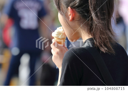 ソフトクリーム　ソフトクリームをなめる女性 104808715