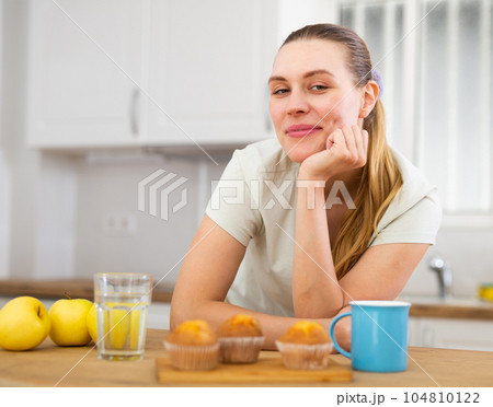 Portrait of young woman drinking morning coffee in modern kitchen 104810122